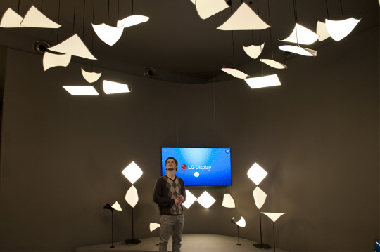 LG디스플레이는 18일부터 오는 23일까지(현지시간) 독일 프랑크프루트에서 열리는 세계 최대 조명·건축전시회인'라이트&빌딩(Light&Building) 2018' 에 참가해 다양한 유기발광다이오드(OLED) 조명 제품과 기술을 선보인다고 18일 밝혔다. CSO 기술은 OLED 패널을 진동판으로 이용해 패널이 직접 떨리며 소리를 내는 기술이다. 전시장을 방문한 관람객이 크리스탈 사운드 올레드(CSO) 기술을 적용한 OLED 조명 제품을 감상하고 있다. <LG디스플레이 제공>